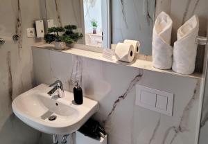 a white bathroom with a sink and a mirror at Moderner Ankerplatz mit Terrasse direkt am Hafen "Momentic" in Neustadt in Holstein
