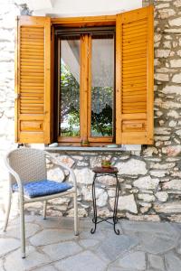 a chair and a table in front of a window at Theologos Nest in Theológos