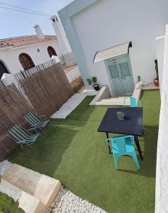 a yard with chairs and a table and a house at Casita de la playa in Rincón de la Victoria