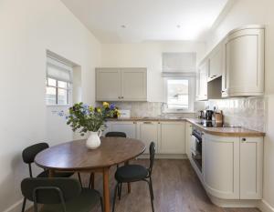 a kitchen with a table and chairs and a vase with flowers at Windyridge in Saint Abbs