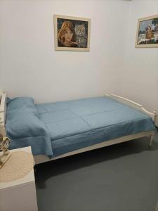 a bedroom with a blue bed with a picture on the wall at Casa Giulia West Samos Lekka Hills Karlovasi 3BR Village Home in Samos +14 photos