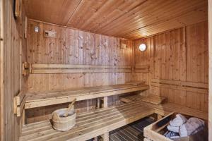 an empty wooden sauna with a bucket in it at Résidence Odalys Nakâra in Cap d'Agde
