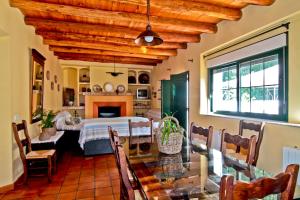 a dining room with a table and a living room at LA SERRERÍA in Galaroza