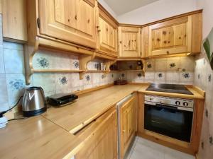 Cozy flat in amazing central location في كورتينا دامبيتزو: مطبخ بدولاب خشبي وموقد