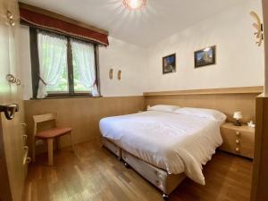 Cozy flat in amazing central location في كورتينا دامبيتزو: غرفة نوم بسرير كبير ونافذة