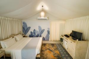 The Fern Seaside Luxurious Tent Resort Daman, Series by Marriott في دامان: غرفة نوم بها سرير أبيض كبير وتلفزيون +35 صورة