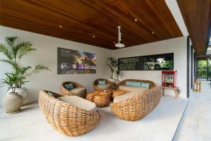 a living room with wicker chairs and a tv at Villa Baliga Ubud by BaliSuperHost in Ubud