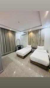 a room with two beds and a tv in it at شقق درة الغيم للشقق المخدومة in Taif