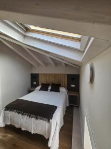 a bedroom with a large bed with a skylight at La Barata Apartamentos in Colombres