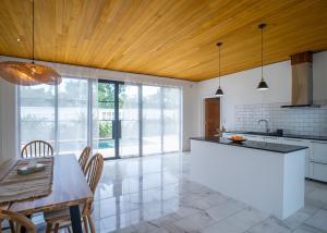 a kitchen with white cabinets and a wooden ceiling at Bahandi Villas in Panglao