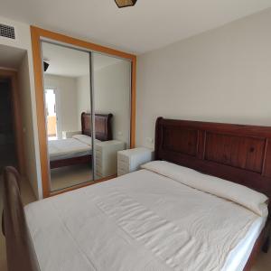 a bedroom with a bed and a large mirror at Apartamento Luminoso con terraza y parking privado - Vera Playa in Playas de Vera