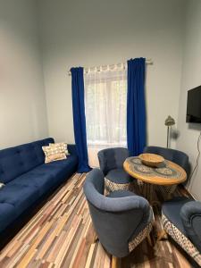 ユールマラにあるMadam Brioche Apartmentsのリビングルーム(青いソファ、椅子、テーブル付)