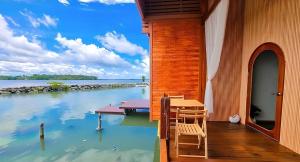 een huis op het water met een tafel en stoelen bij 44Kohsaraihomestay 44เกาะสาหร่ายโฮมสเตย์ in Satun