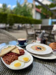 ユールマラにあるMadam Brioche Apartmentsのテーブルの上に卵と豆の皿が2枚