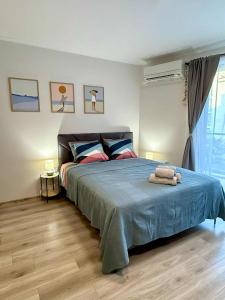 a bedroom with a large bed with a blue blanket at Studio Moré in Shkorpilovtsi +30 photos