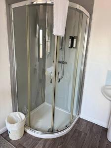 a shower with a glass door in a bathroom at Cabin 4 in Bradwell on Sea