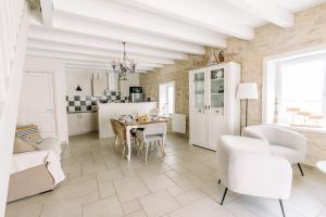 eine Küche und ein Wohnzimmer mit Tisch und Stühlen in der Unterkunft La Do Ré - Élégante et chaleureuse maison à La Noue in Sainte-Marie-de-Ré