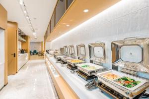 a buffet line with plates of food on display at Atour Hotel Hangzhou West Lake Cultural Plaza Shangtang Road in Hangzhou