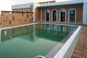 a pool of water in front of a building at Asmi Villa in Kolāra