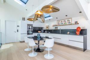 a kitchen with a dining table and white chairs at Villa Elisa - Maison esprit loft 500m plage in Biarritz