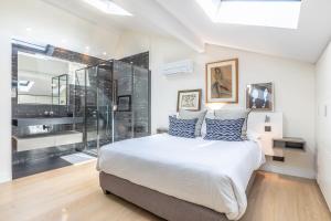 a bedroom with a large bed and a glass wall at Villa Elisa - Maison esprit loft 500m plage in Biarritz