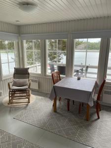 a screened in porch with a table and chairs at Edvin rantamökki in Taalintehdas