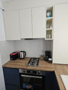 a kitchen with white cabinets and a stove top oven at Silvery Studio 22 in Rădăuţi +4 photos