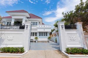 a white house with white gates at Villa Luxury Hồ Bơi Bãi Sau Vũng Tàu in Vung Tau