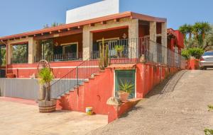 una casa roja con plantas delante de ella en Nice Home In Santa Maria Del Focall, en Santa Maria del Focallo