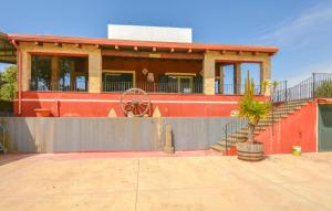 una casa con un edificio rojo con una rueda en Nice Home In Santa Maria Del Focall, en Santa Maria del Focallo