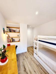 une chambre avec deux lits superposés et une table dans l'établissement Villa Paradis 2 Soleil Mer Plage, à Valras-Plage