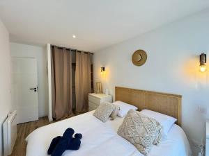 - une chambre dotée d'un lit blanc avec un ours en peluche dans l'établissement Villa Paradis 2 Soleil Mer Plage, à Valras-Plage