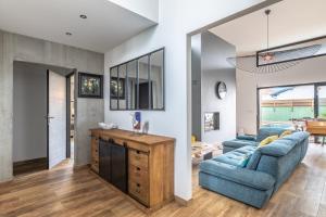 a living room with two blue couches and a table at Villa Samare - Avec piscine à 5 min des plages in Anglet