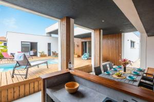 an open kitchen and living room with a view of a house at Villa Samare - Avec piscine à 5 min des plages in Anglet