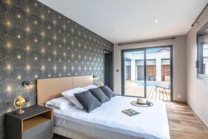 a bedroom with a bed and a wall with lights at Villa Samare - Avec piscine à 5 min des plages in Anglet +13 photos