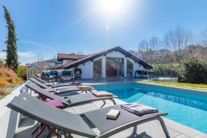szereg leżaków przy basenie w obiekcie Villa Olaina - Villa climatisée avec piscine w mieście Saint-Jean-de-Luz
