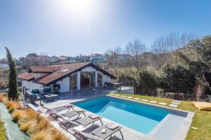 basen z leżakami i dom w obiekcie Villa Olaina - Villa climatisée avec piscine w mieście Saint-Jean-de-Luz
