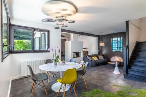 a living room with a table and chairs at Villa Julia - Villa contemporaine avec piscine in Anglet