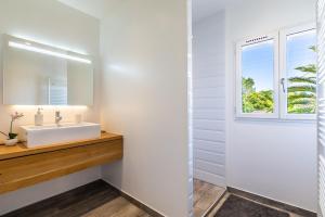 a bathroom with a sink and a window at Villa Julia - Villa contemporaine avec piscine in Anglet