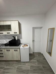 a kitchen with white cabinets and a counter top at ViS APARTMAN in Trebinje +8 photos