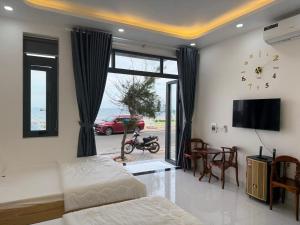 a bedroom with a bed and a tv and a table at Oyster homestay in Chợ Phước Hải