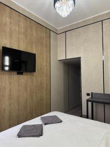 a bedroom with a bed and a tv on a wall at Magistral 2 Hotel in Bishkek