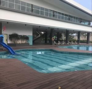 a swimming pool with a slide in front of a building at d'Fun 5BR16-24px Pool BBQ NetFlx HotPot KTV Mahjong by Our Stay in Ulu Tiram