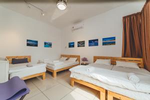 a bedroom with two beds and a blue chair at d'Fun 5BR16-24px Pool BBQ NetFlx HotPot KTV Mahjong by Our Stay in Ulu Tiram +86 photos