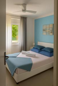 a bedroom with a bed with blue pillows and a window at City apartment Blue Vibes in Pula