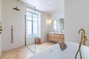 a white bathroom with a tub and a sink at Villa Mila - A 450 m de la plage in Biarritz