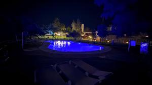 Una piscina de noche con luces azules en Crisol Jardines de Córdoba, en Córdoba