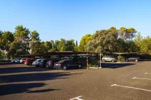a parking lot with cars parked under a canopy at Crisol Jardines de Córdoba in Córdoba