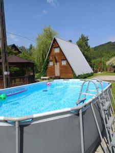 a swimming pool with a house in the background at Domek u Marty in Solina