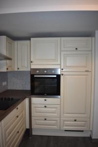 a kitchen with white cabinets and a microwave at CoCo Villa in Makarska